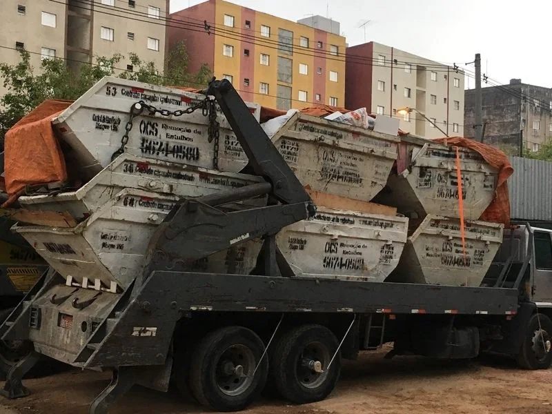 Caminhão transportando várias caçambas